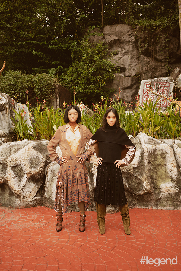 On Mei Yue [left] Gold knitted turtleneck, yellow slip dress, camel-embroidered dress, brown stockings and belted boots_Chloé / On Layla [right] Silk printed blouse, black cape and black pleated skirt_Shanghai Tang; Brown suede tasselled boots_Longchamp
