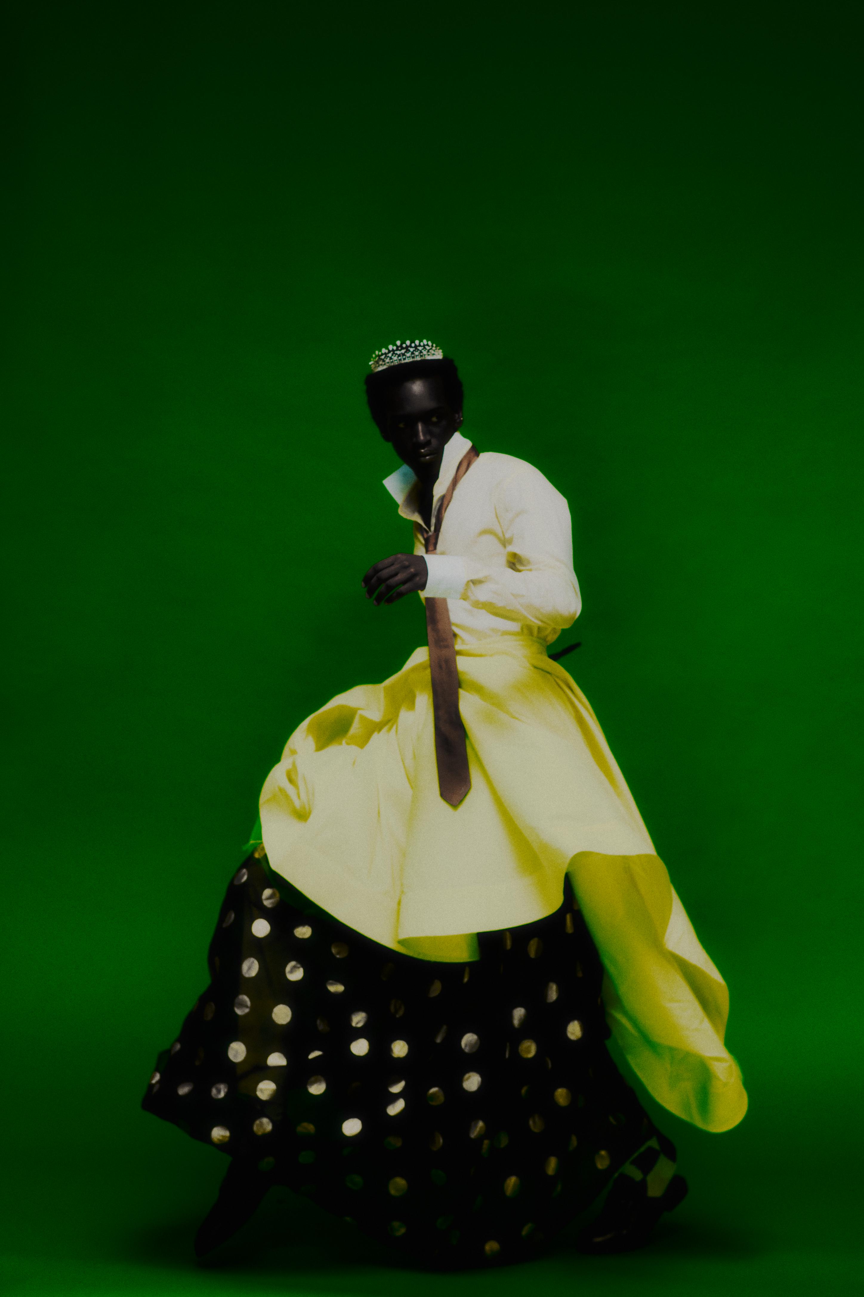 Serpent Bohème tiara _ Boucheron; Cream shirt and brown tie _ Prada; Black and gold polka dot dress _ Dolce&Gabbana; Yellow skirt _ Vivian Luk Atelier