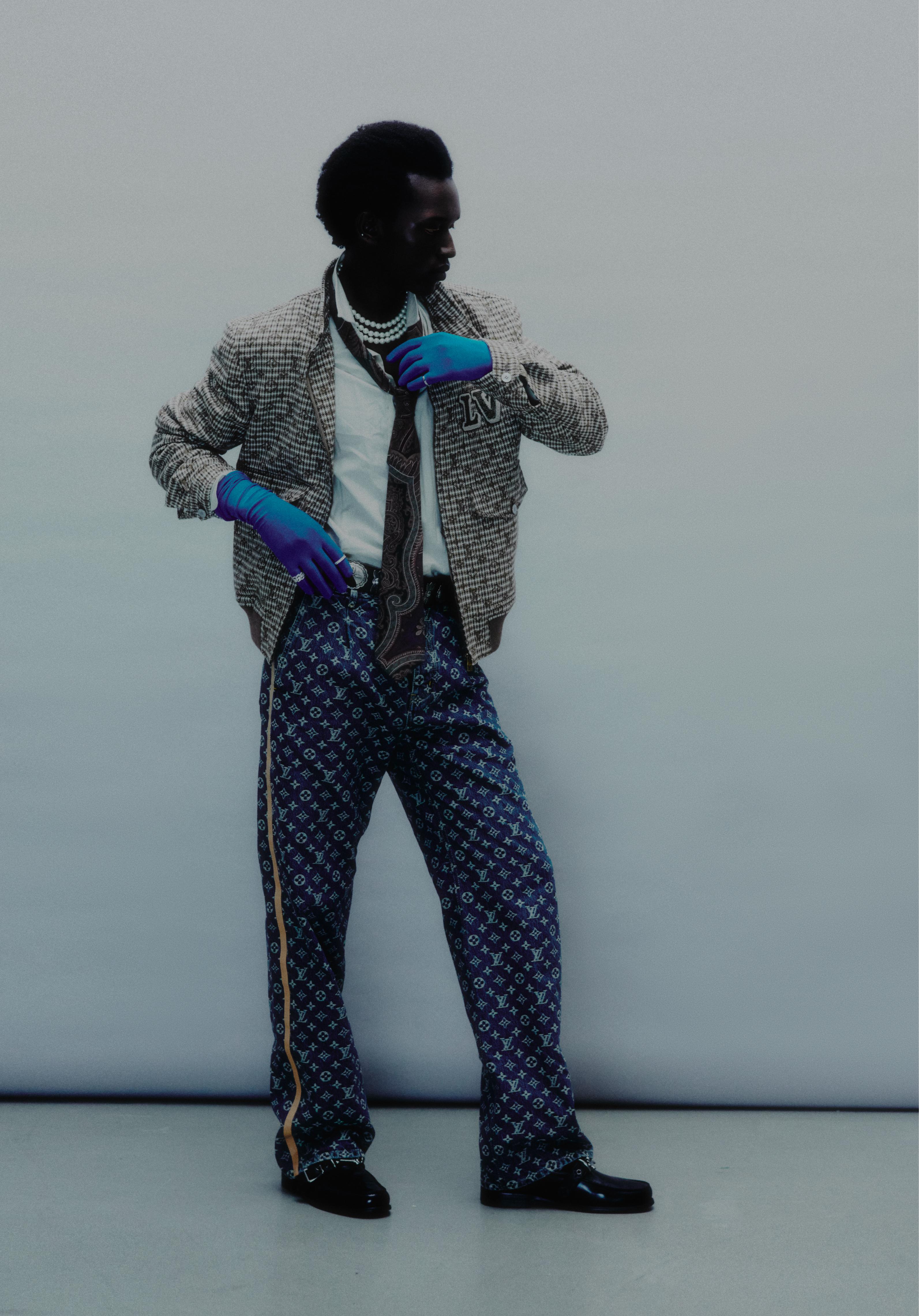 Ring with round diamonds, eternity ring with emerald-cut diamonds, and GRAFF ring with round diamonds _ Graff; Brown monogram jacket, blue monogram jacquard denim trousers, white monogram shirt and black loafers _ Gucci; Brown printed tie and embellished leather belt _ Ralph Lauren (Stylist’s own gloves)