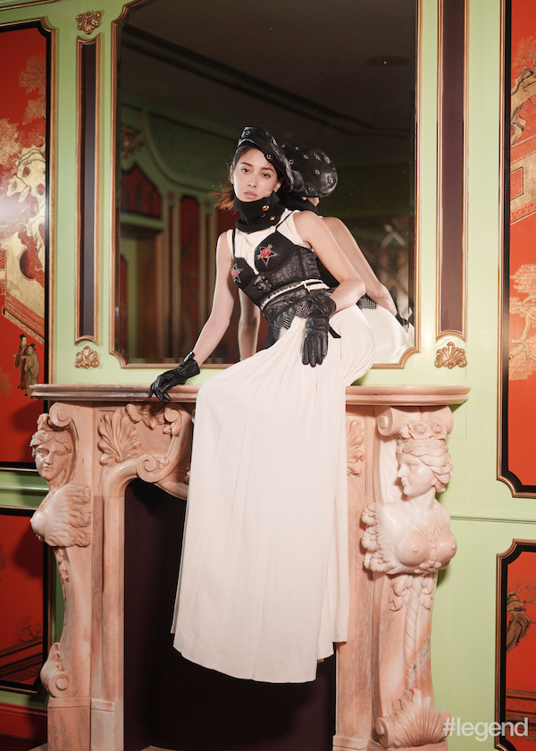 Black leather beret with metal eyelets and gloves by Claudie Pierlot; black knitted scarf by Sacai; ivory silk gown by Lanvin; black corset bra with rose appliqué and black garter by Intimissimi