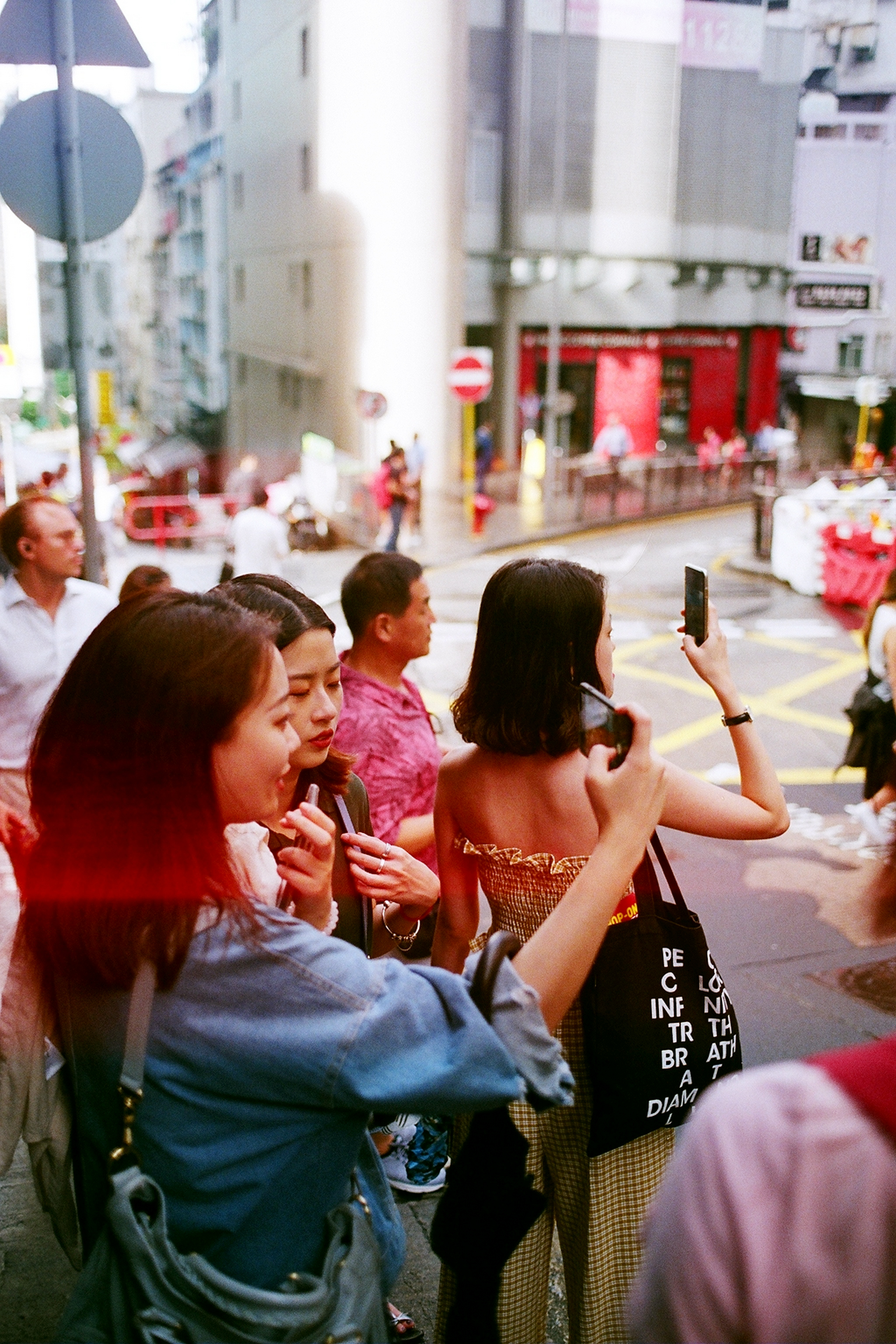 People flocking across the street with their cameras aimed