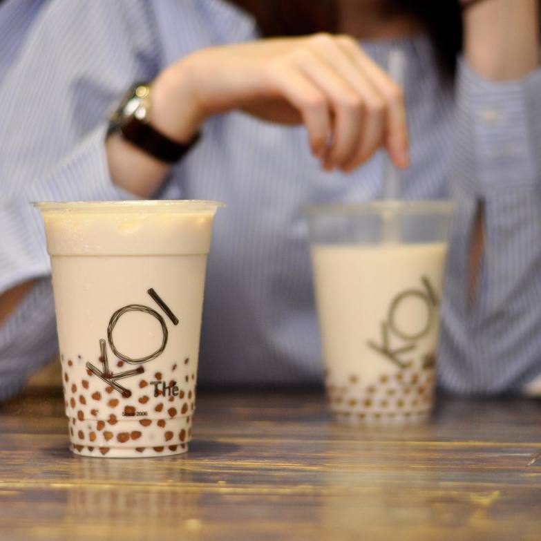 A cup of KOI Thé bubble tea rests on a table (credit: @koithethailand)