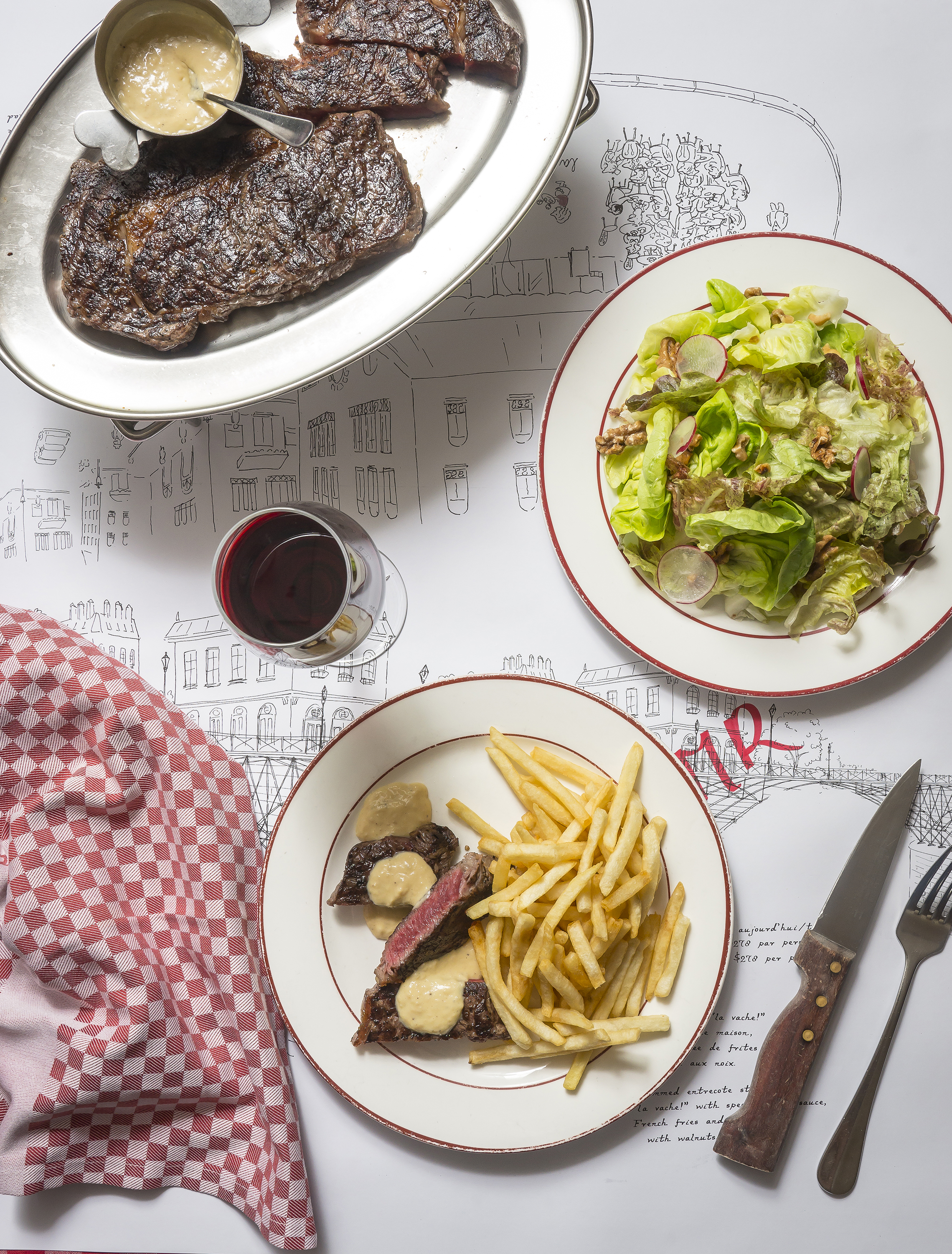 The signature ribeye steak with salad and fries