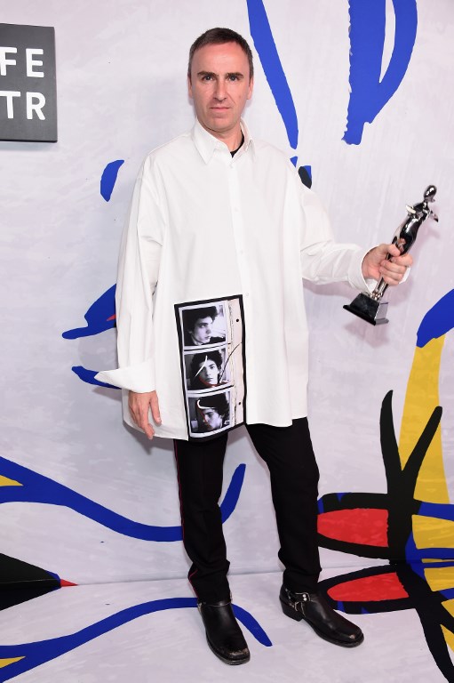 Designer Raf Simons poses with his award at the CFDA Awards (photo by Dimitrios Kambouris | AFP)