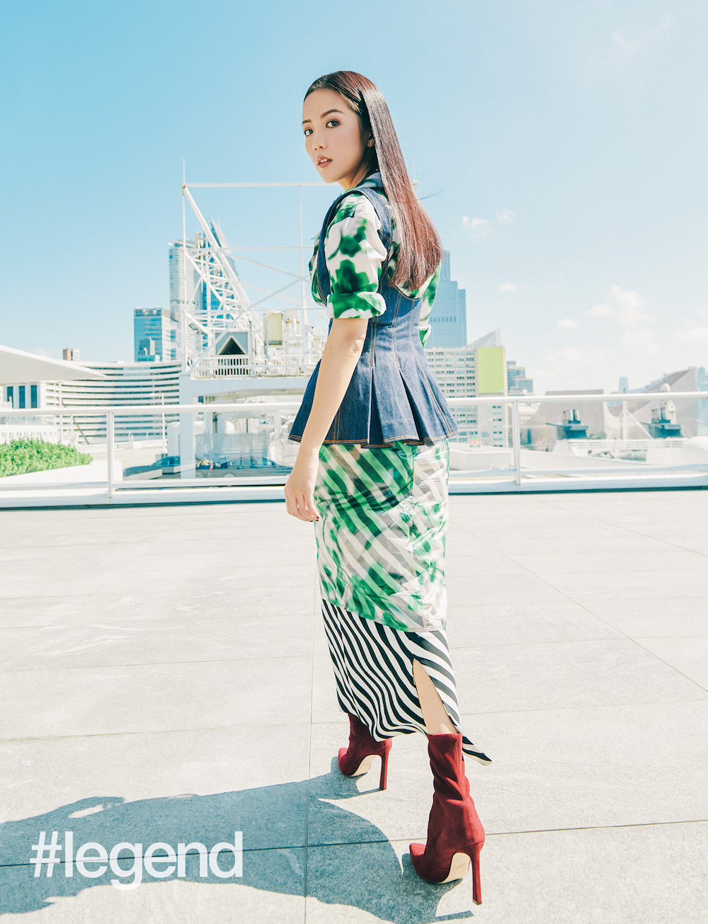 Green and white button-down shirt with print (worn under tank top), black bustier top (worn inside), printed skirt with organza overlay, and collar necklace with feather _ Dries Van Noten by Joyce ; Denim tank top _ Rosie Assoulin by Joyce; Burgundy suede boots by Stuart Weitzman