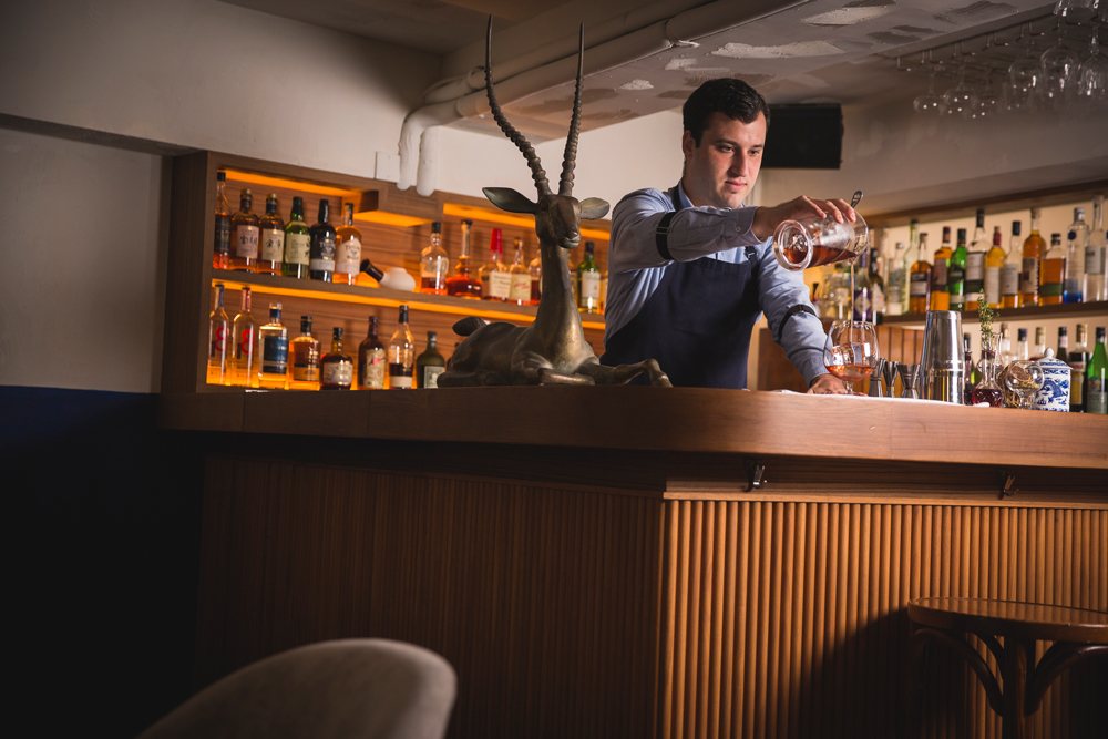 Gonzalez mixes a drink Upstairs at Belon