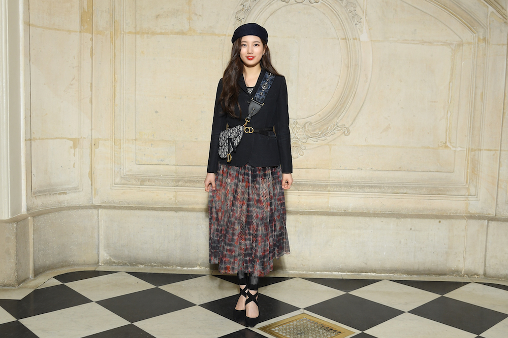 Suzy Bae in Dior Spring-Summer 2019 navy blue wool and silk jacket, a Dior printed silk skirt, a Dior beret, a Dior Saddle bag in blue oblique hessian and Dior shoes.