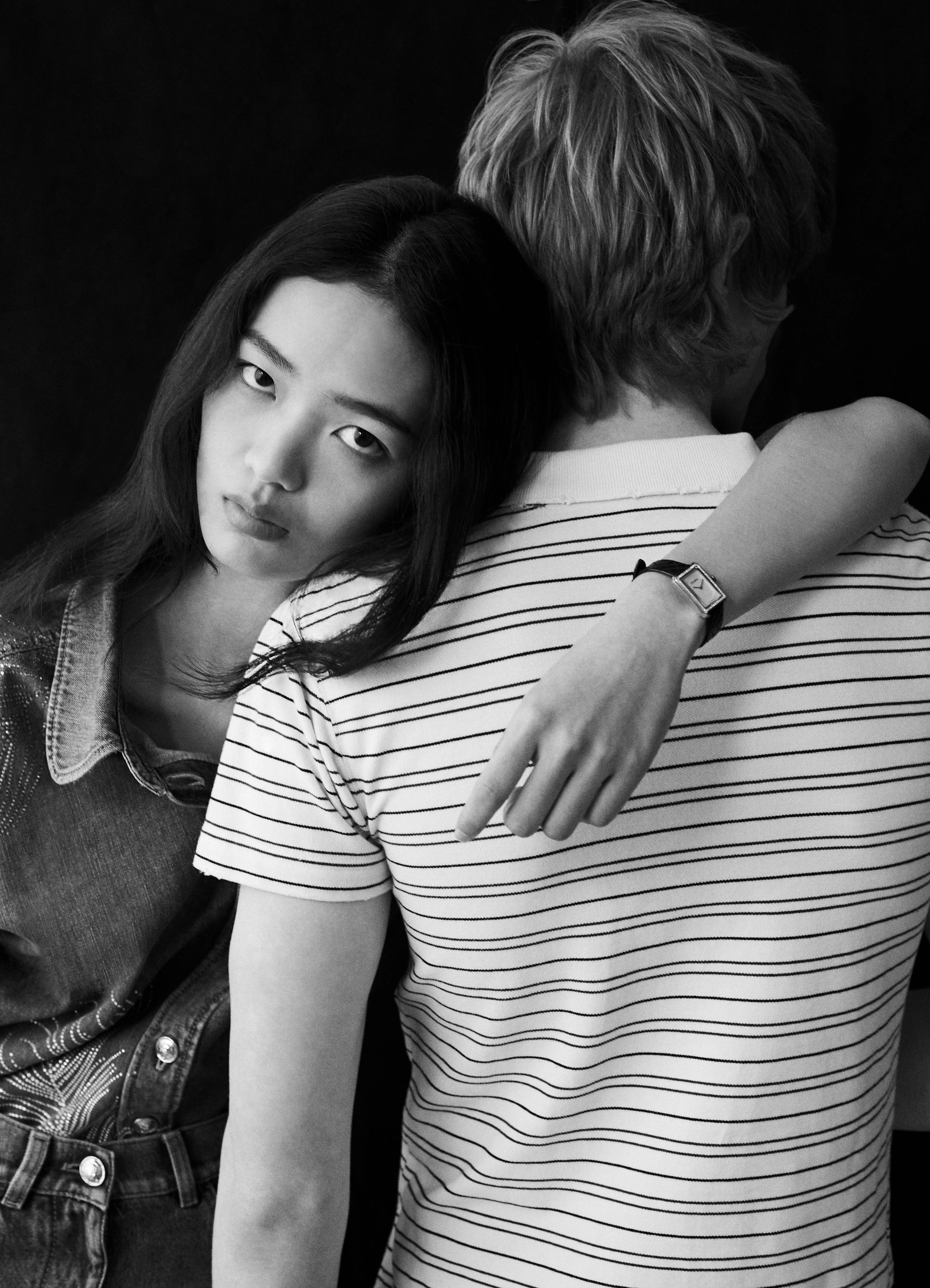 On Yuyu, BOY·FRIEND watch in beige gold with diamonds on quilted-pattern calfskin strap, and denim shirt and trousers _ Chanel; On Mason, Striped polo shirt _ Balenciaga